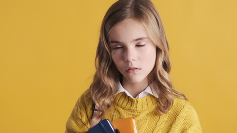 Sleepy-teenage-Caucasian-girl-student-holding-notebooks.