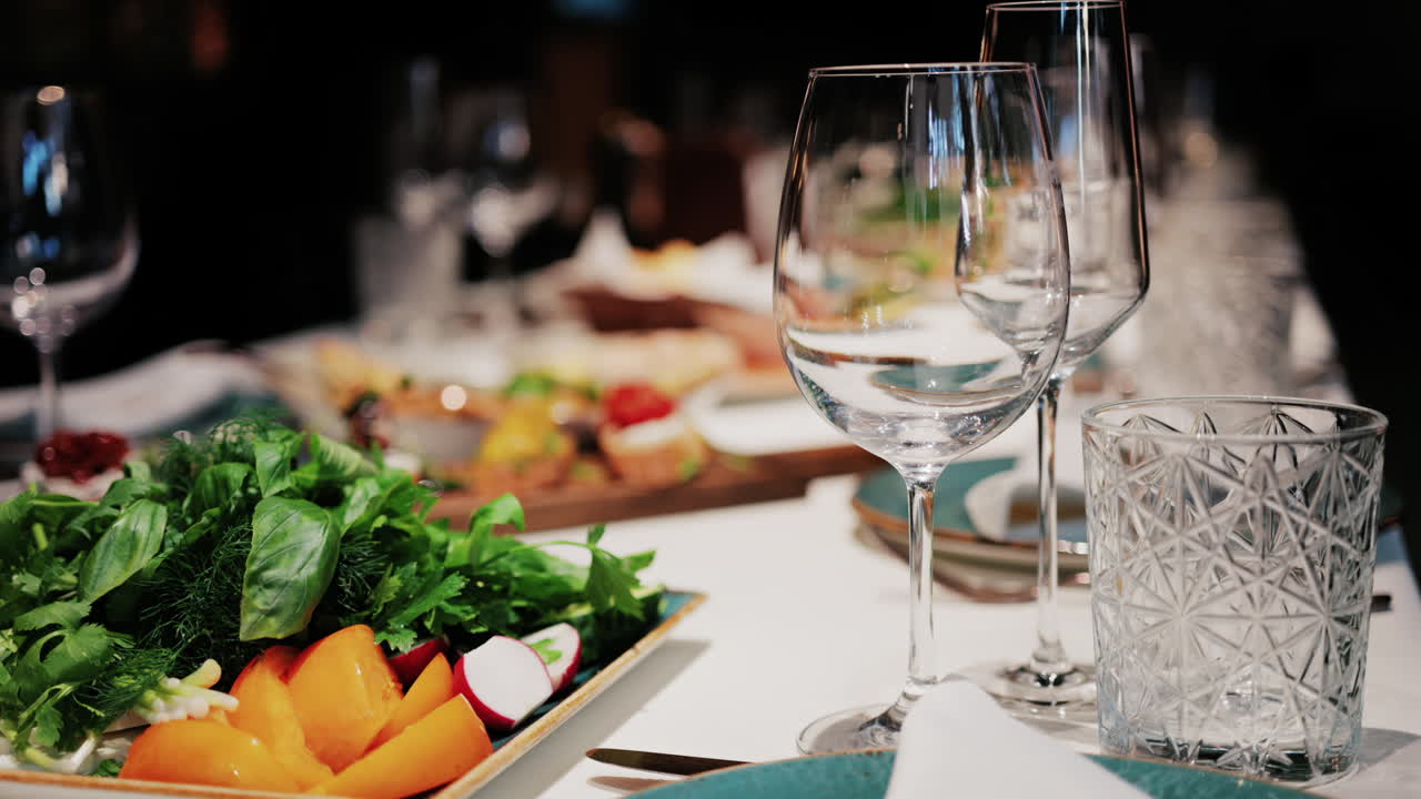 Refined restaurant table setting with crystal glasses, plates, and gourmet dishes in the background