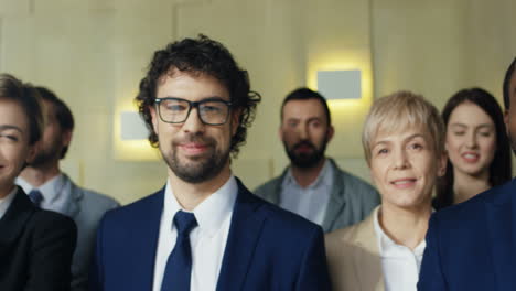 close-up view of multiethnic group of business people wearing formal clothes and smiling at a big meeting