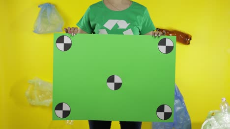 unrecognizable woman holding chroma key poster with tracking points. environment plastic pollution