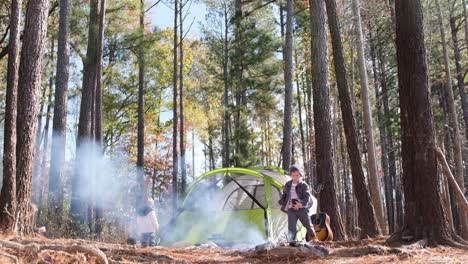family camping with kids tent and guitar under tall pine trees a lovely family camping scene shows children playing a cozy tent and a guitar among tall majestic pines