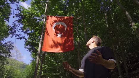 young muslim praying looking at turkish flag. slow motion.