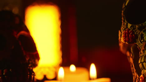 close up on still life of decorated skulls lit by candles celebrating mexican holiday of dia de muertos or day of the dead 4