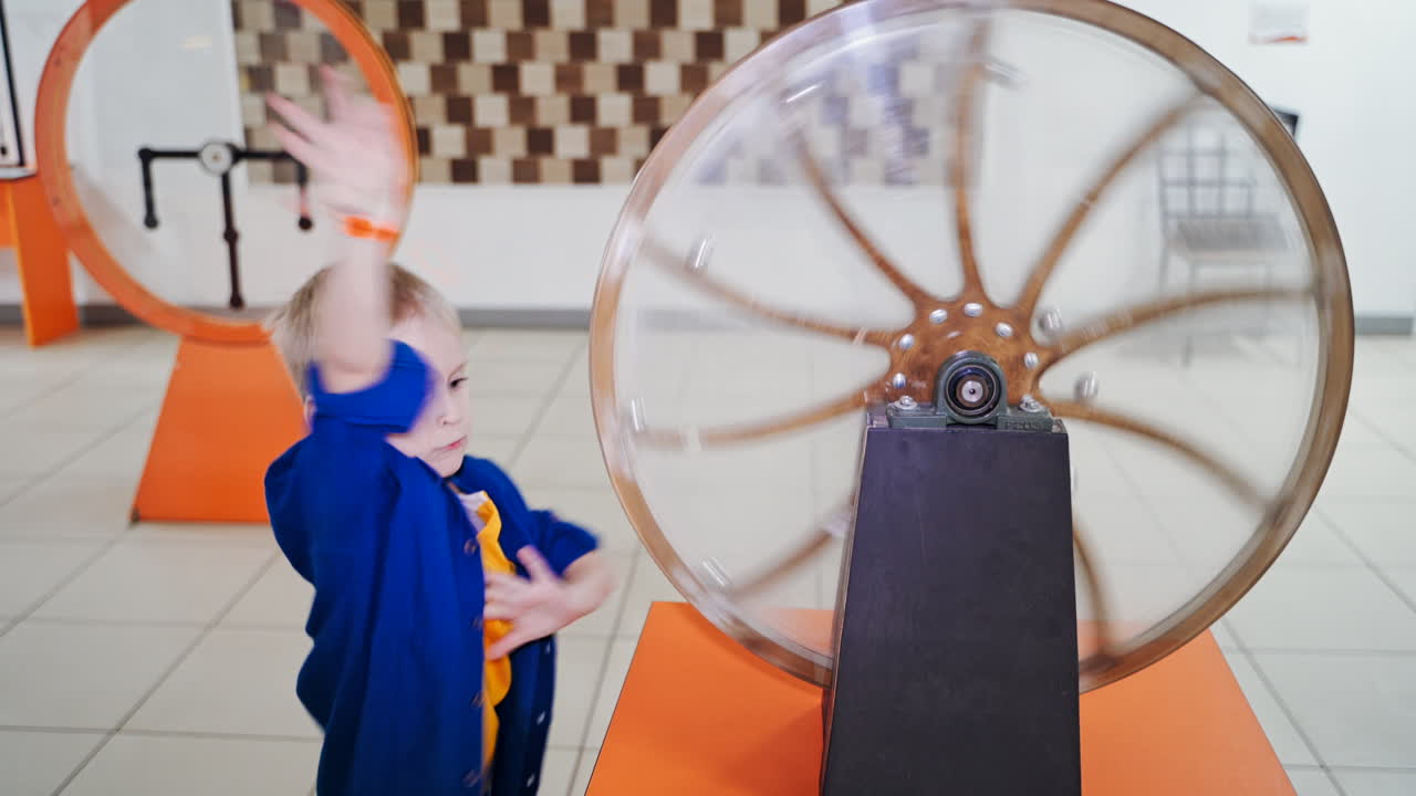 The boy examines the perpetual motion machine. Scientific Exhibition Center