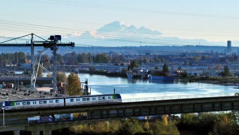 skytrain traveling on canada line rapid transit system over the fraser river to marine drive station in canada