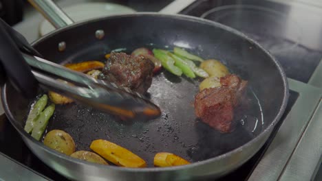 cooking steak with vegetables in a pan