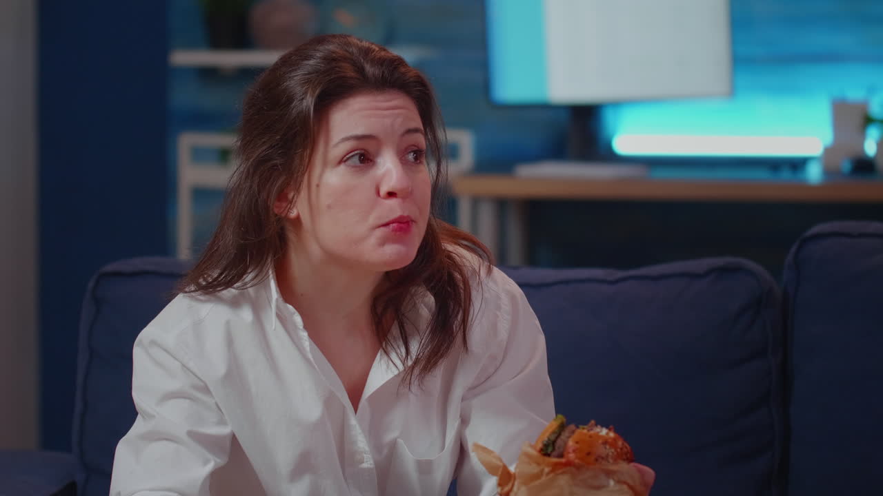 Close up of businesswoman eating fast food meal on couch