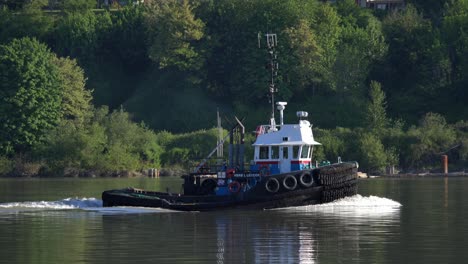 tug boat cruising in the fraser river in daytime in british columbia, canada