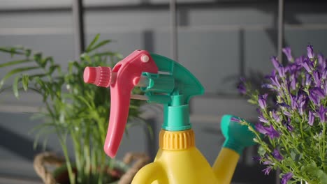 close up of a watering can and a spray bottle for plants