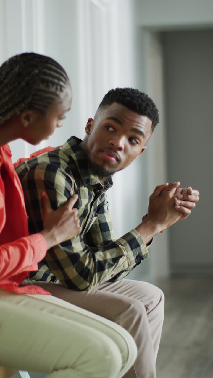 Vertical video of african american woman comforting male partner