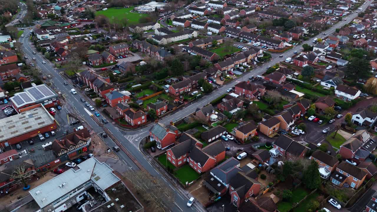 Landscape drone footage panning over the Locks Heath area in Hampshire, South England. A small village near Southampton with a beautiful golden sunset overhead and small suburban houses below