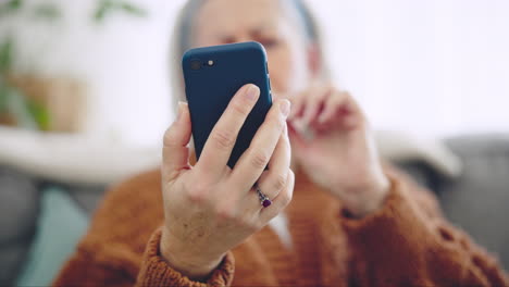 Phone,-hand-and-closeup-of-senior-woman-scroll