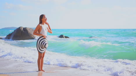 Mujer-Caminando-Por-Las-Olas-De-Agua-De-Mar-En-Una-Playa-De-Arena