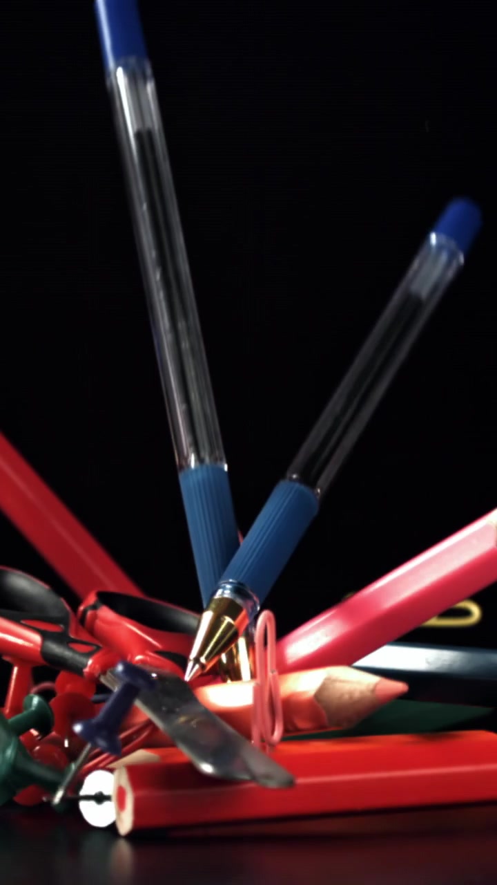Slow Motion of Colorful Stationery Falling onto a Dark Surface