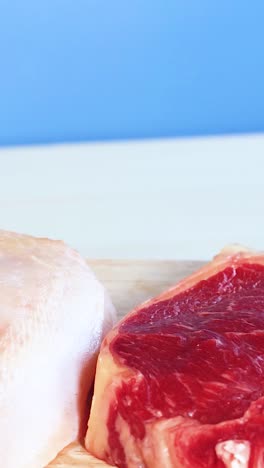 una vibrante exhibición de varios alimentos proteicos, incluidas carnes, mariscos y nueces contra un fondo azul