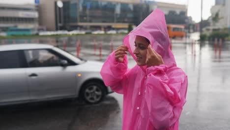 woman in pink raincoat enjoying a rainy city day