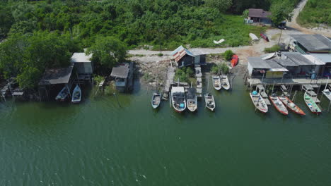 rows of boats and settlements along bagan lalang river in morning, malaysia