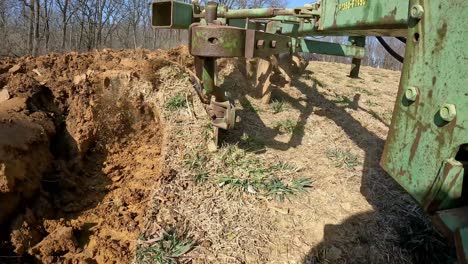 close up of plow chisel and turning soil when farmer tows the plow