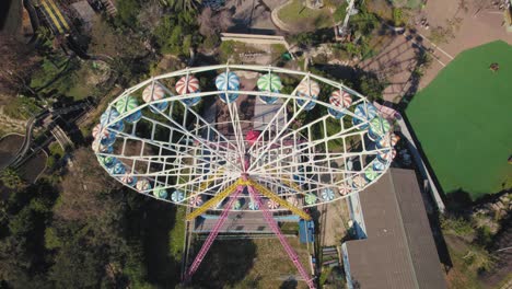 ferris wheel spins in a small theme park - top down to pullback reveal shot