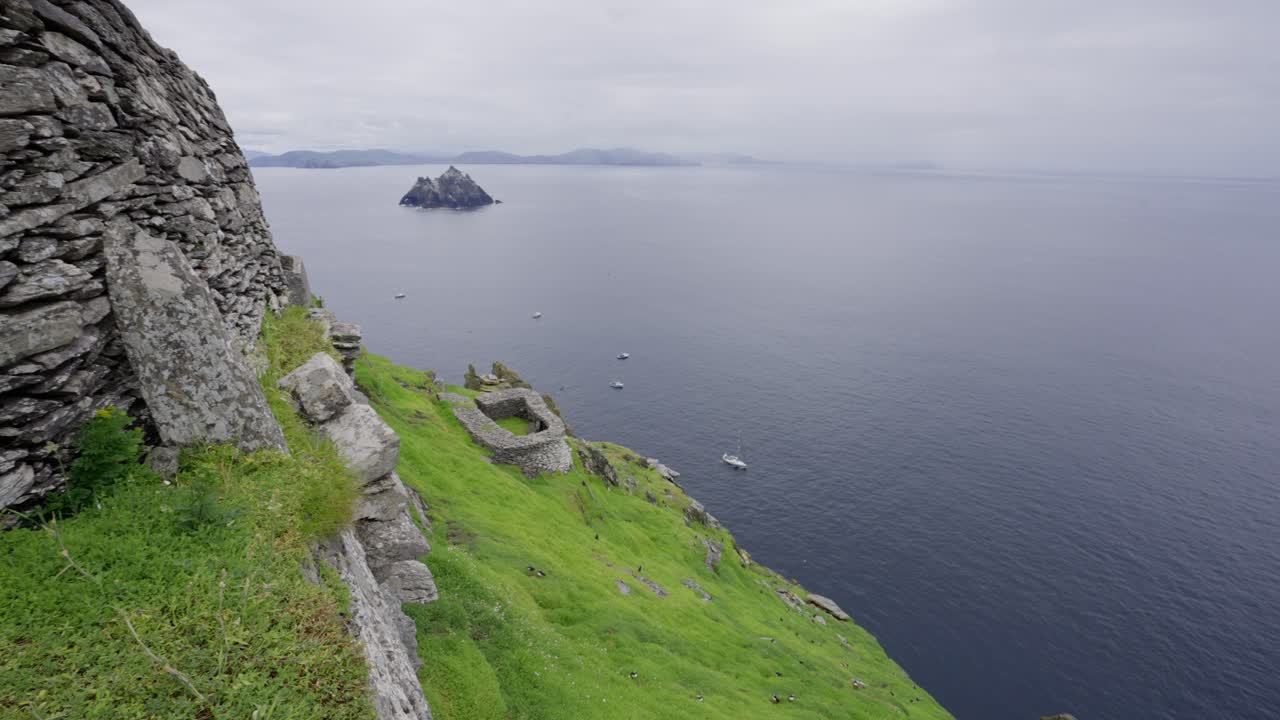 Pan along the temple wall at the top of Skellig Michael in Ireland