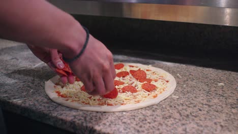 Salamistücke-Werden-Auf-Der-Pizza-Verteilt