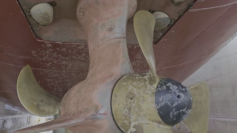 close up of thruster of large ship in dry dock at shipyard, slow pedestal down.