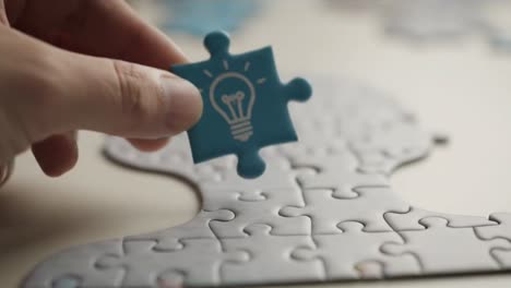 hand holding a puzzle piece with a lightbulb idea icon