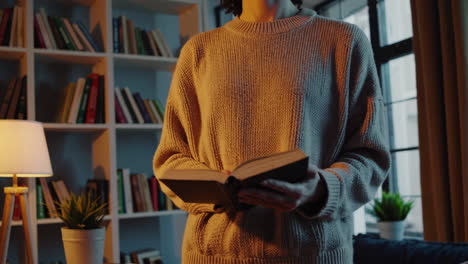 woman reading in a cozy home library at night