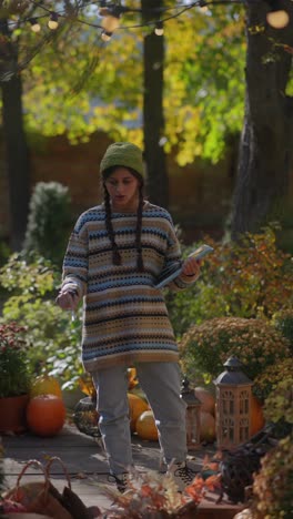 woman taking pictures of an autumn garden display