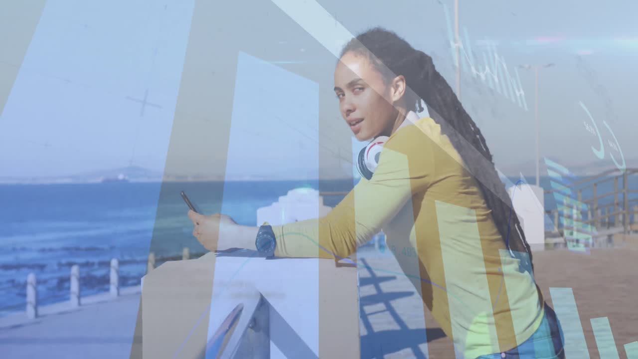 Animation of statistics and graphs over woman using smartphone on promenade by the sea