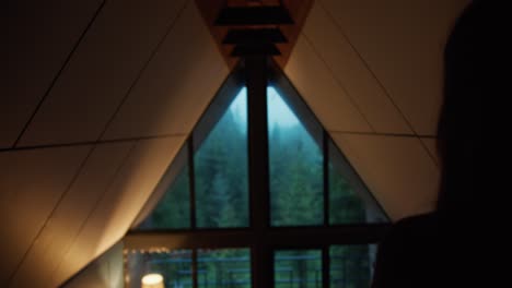 Silhouette-of-a-girl-who-looks-out-the-window-at-the-green-forest-in-the-mountains.-Nice-view-from-the-window