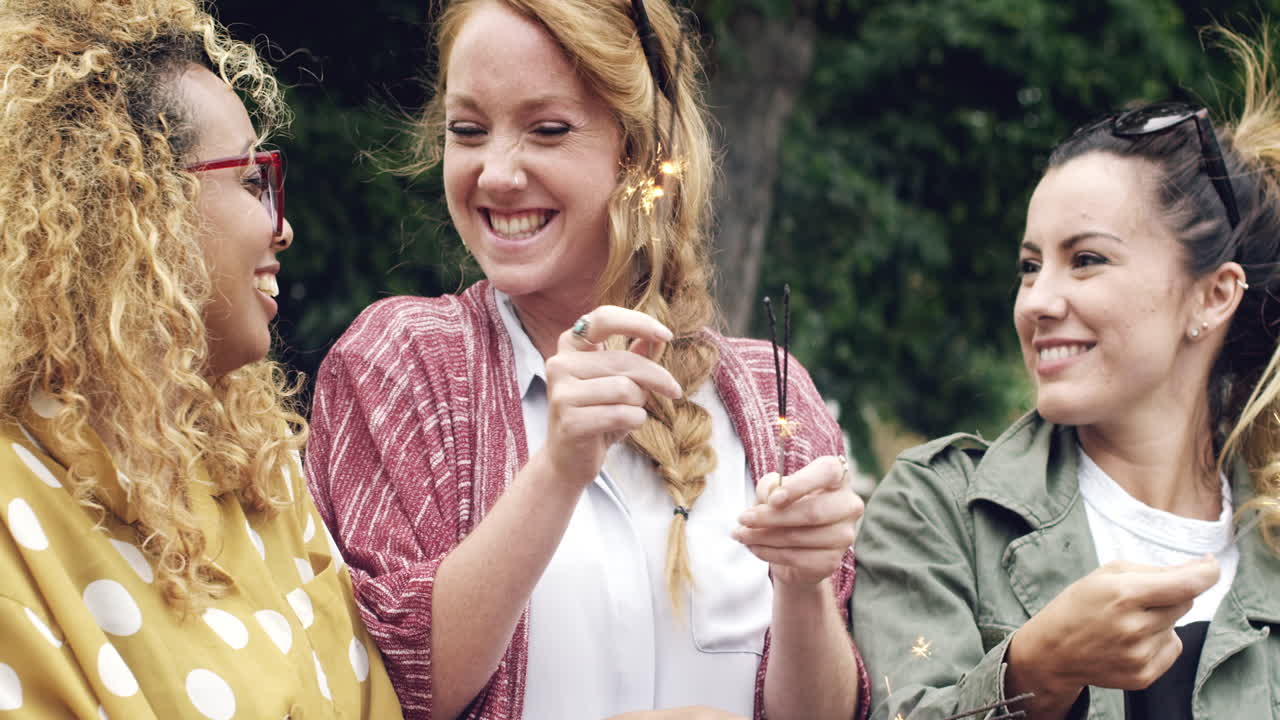 7월 4일 독립기념일인 새해를 축하하는 불꽃을 들고 있는 여자 친구들