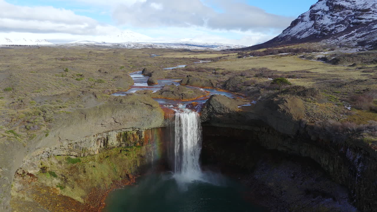 Drone descending towards Agrio Waterfall (Salto del Agrio) near Caviahue, Neuquén Province, Argentina, where the Agrio River drops into a deep volcanic pool surrounded by rugged basalt cliffs