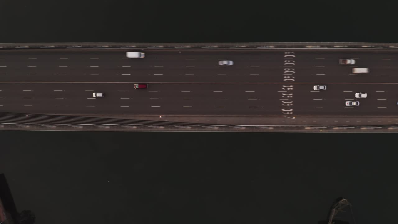 vista aérea de un avión no tripulado del tráfico que fluye sobre un puente suspendido a través de un río