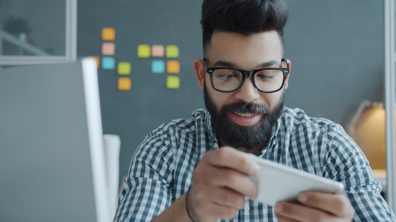 Man Playing a Game on his Smartphone in the Office