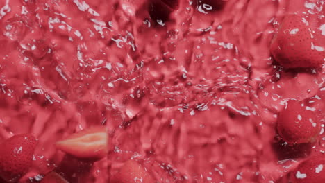 video de fresas cayendo en el agua con espacio de copia en fondo rojo