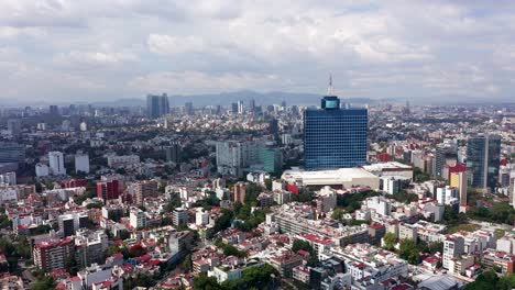 aerial view over the city, away from the wtc, with a facemask-like artifact at the top due to covid19 pandemic, partly sunny day, in mexico, america - pull back, drone shot