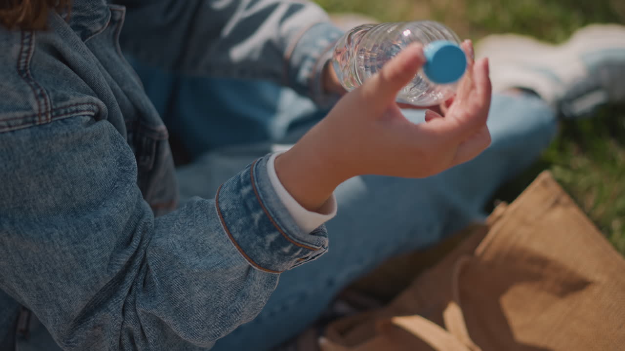 Una donna esamina gli attrezzi da picnic all'aperto oggi. La donna ispeziona accuratamente i suoi accessori da picnic all'aperto oggi. Controlla metodicamente tutte le sue provviste per il picnic all'aria aperta oggi