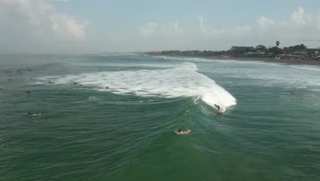 surf en las olas del océano índico aéreo, surfistas en la isla de bali, indonesia, playa canggu