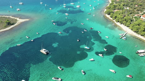 blue lagoon with yachts, boat, and catamaran anchored in blue sea near drvenik veli island in croatia. - aerial