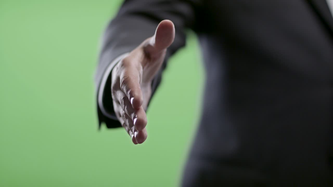 un apretón de manos de un hombre de negocios en la pantalla verde.