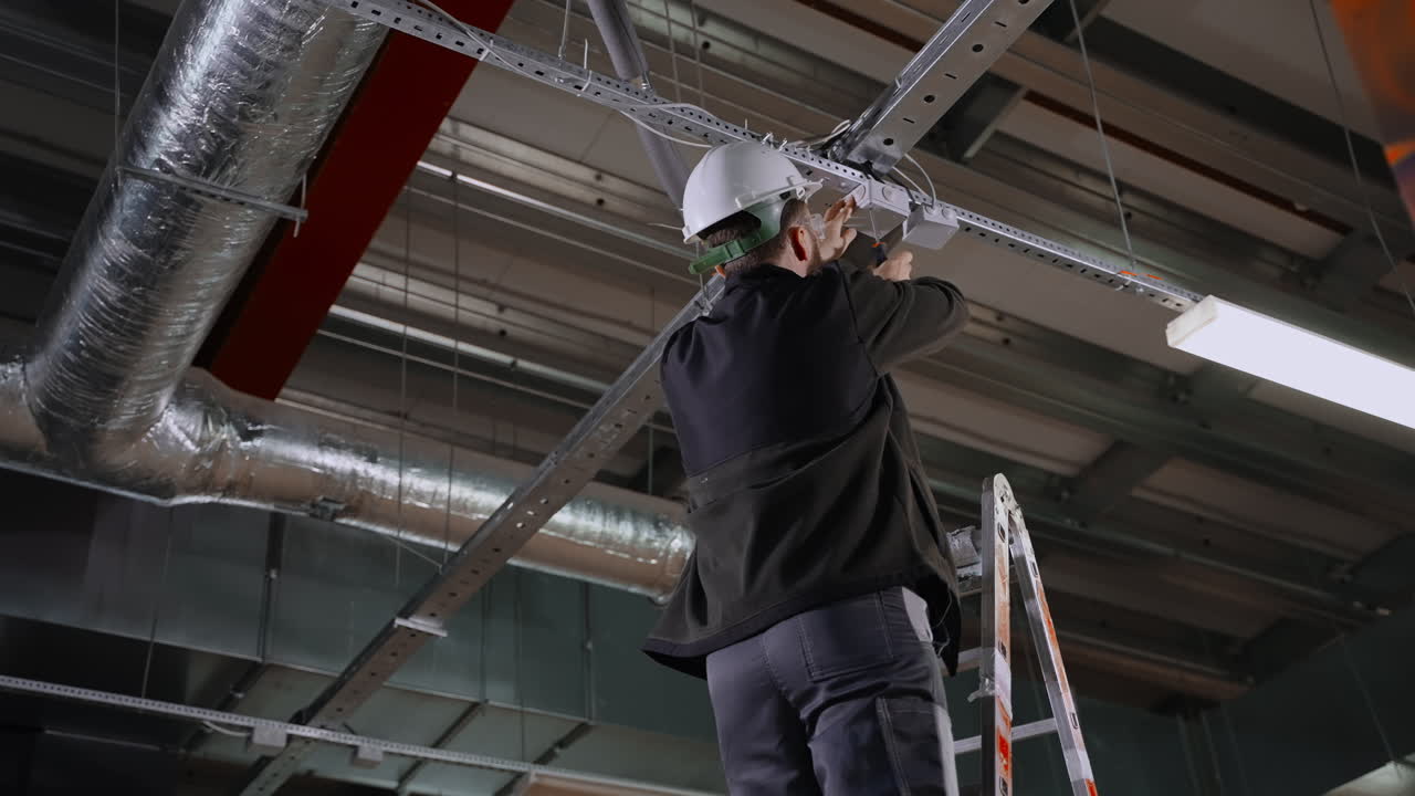 Industrielektriker arbejder på loftslamper