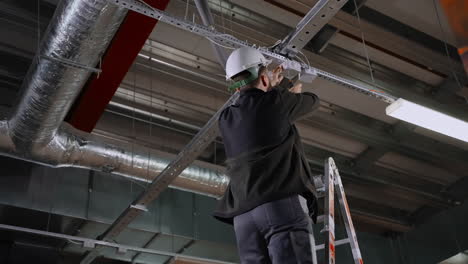 industrial electrician working on ceiling lights