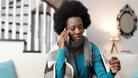 Close-up-portrait-of-sick-woman-wearing-a-scarf-and-speaking-on-cellphone