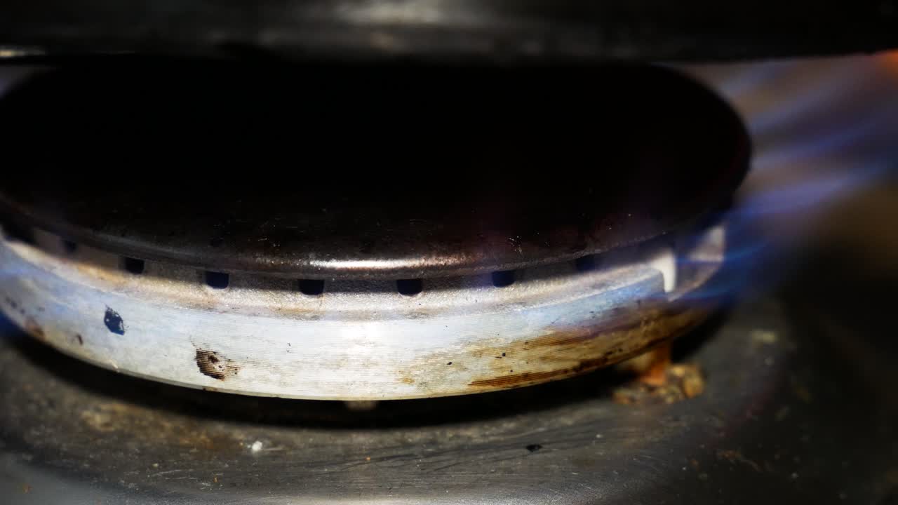 더러운 가스레인지나 부엌 버너가 푸른 불꽃으로 타고 있다