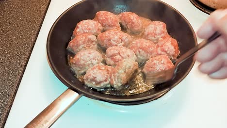 swedish meatballs cooking in frying pan