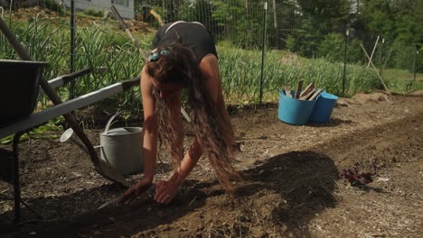 girl with long hair planting seeds in farm