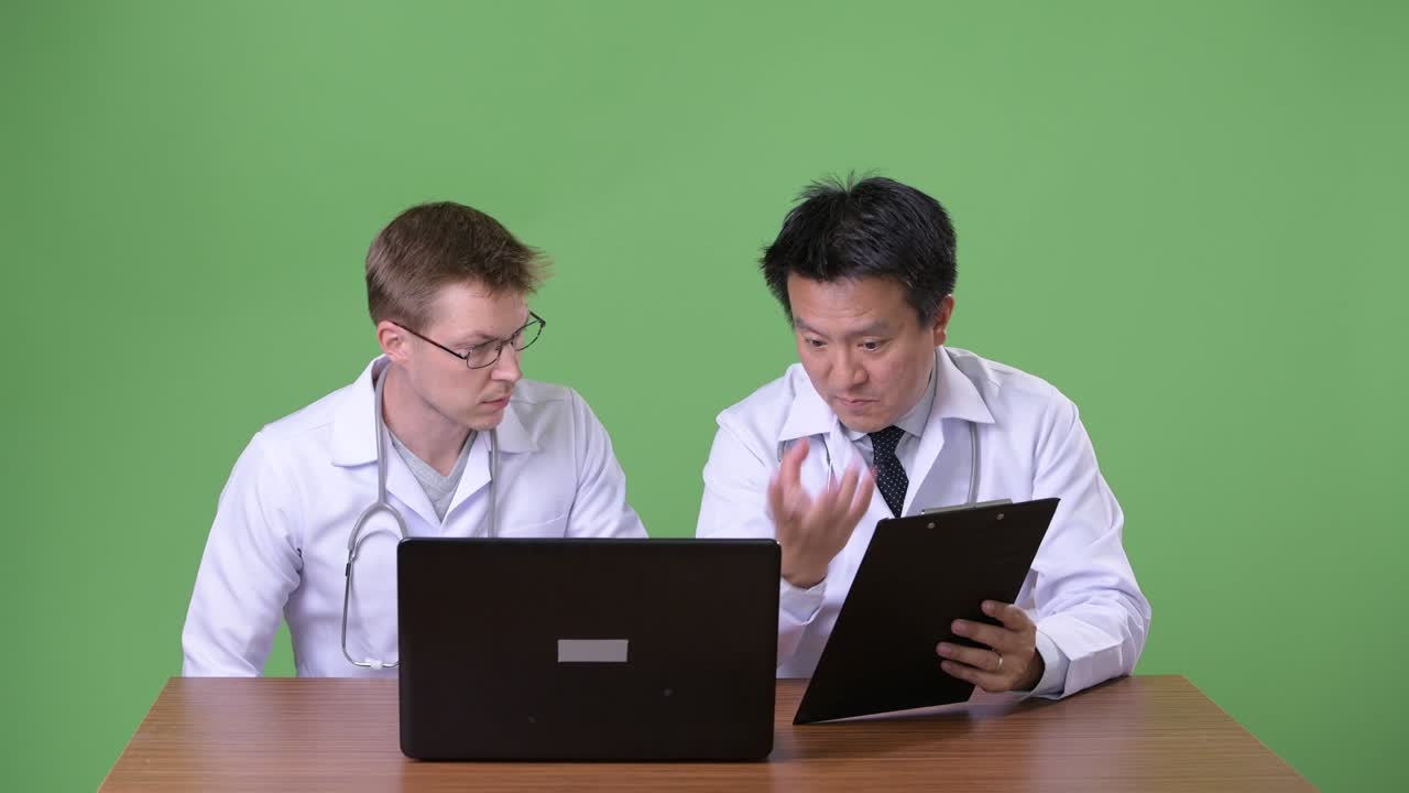 초록색 배경에 두 명의 다민족 의사들이 함께합니다.