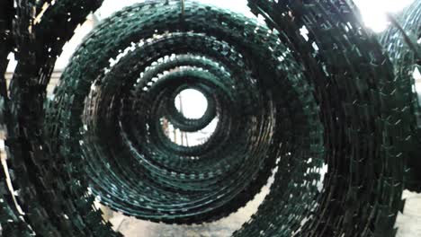 oiled rolls of barbed security wire being hanging out to dry