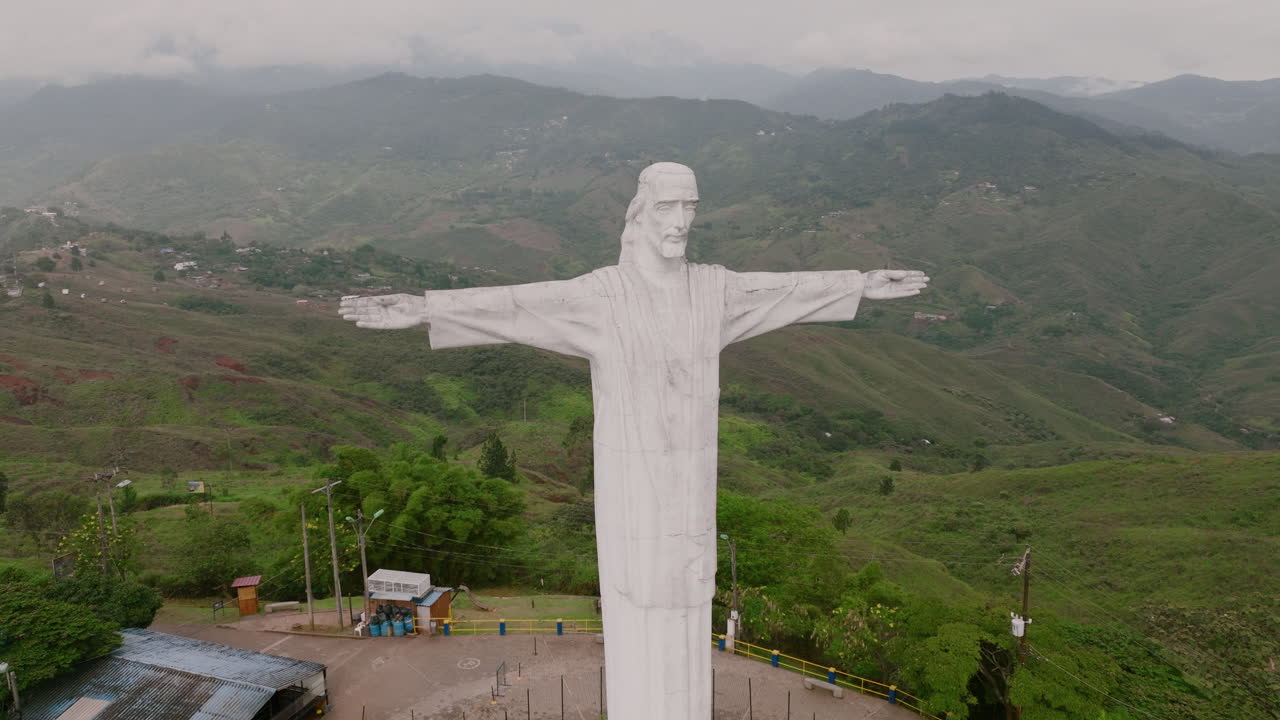 tomas aéreas lentas frente a la estatua de cristo rey jesús en la cima de una montaña en las afueras de cali, colombia